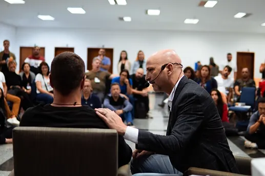 Marcelo Behn conduzindo uma prática com um participante diante da turma